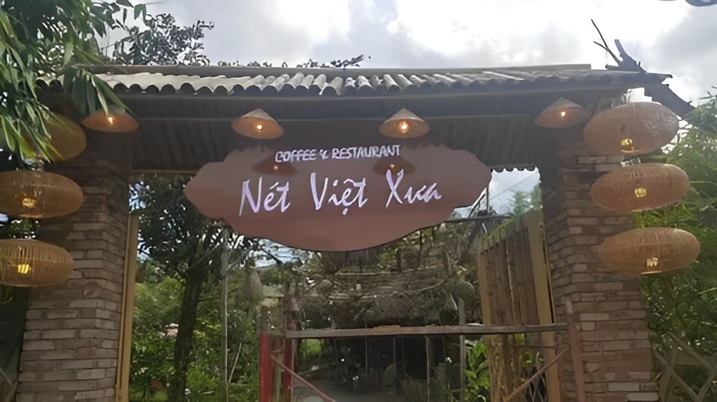 Thiết kế nón lá nhỏ treo xung quanh bảng hiệu bằng gỗ tại quán cafe sân vườn Nét Việt Xưa